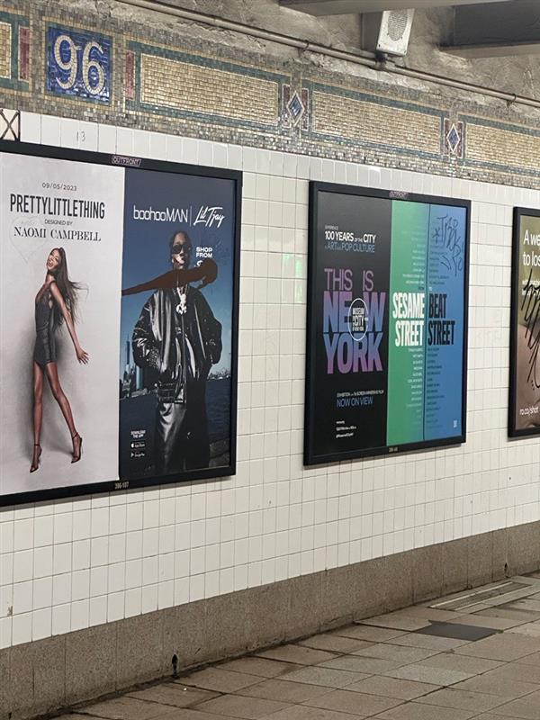 Subway card ad for the exhibition "This Is New York" on the platform at 96th street.