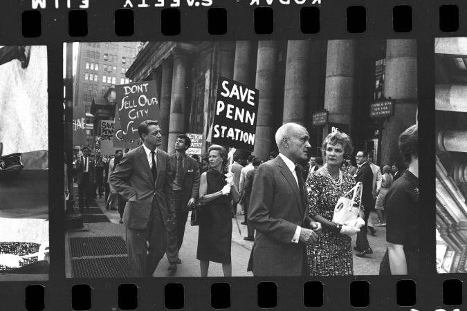 A group of marchers hold signs protesting the demolition and renovation of Penn Station