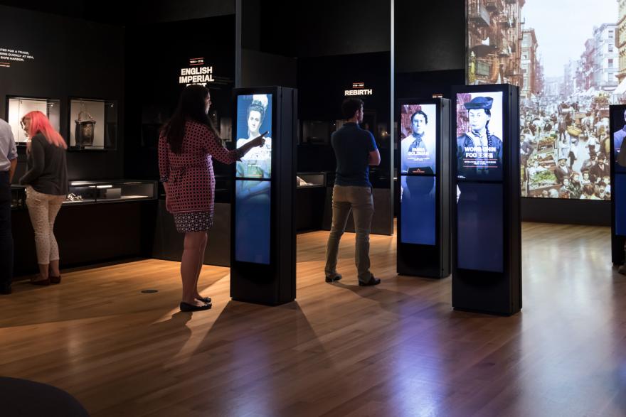 A small crowd standing in a gallery with interactive screens