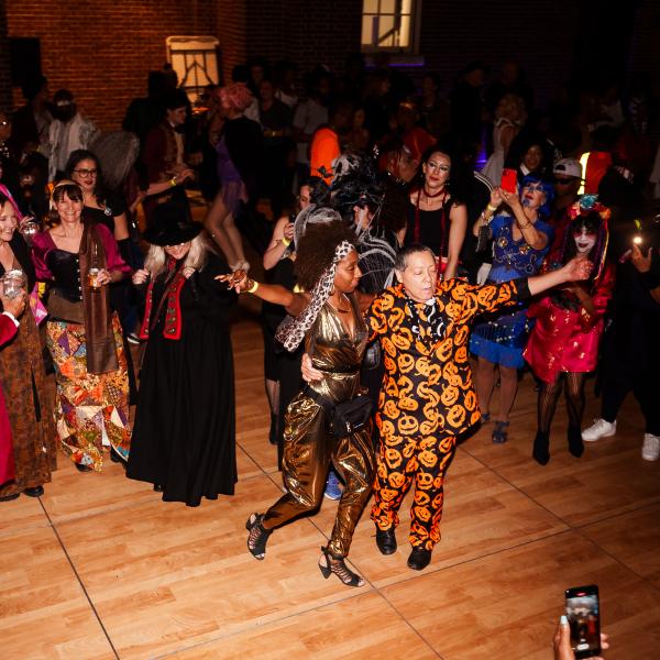  A lively crowd in colorful costumes enjoys dancing and celebrating at a Halloween party