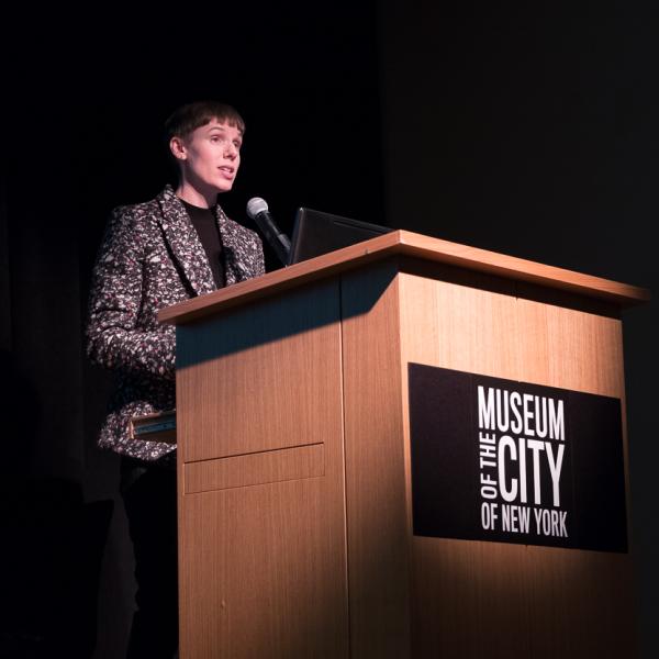 Sarah Seidman standing in front of a podium with black background