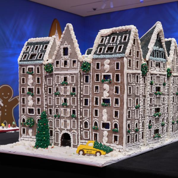 Gingerbread creation of the Dakota Hotel with a yellow taxi out front with snow and Christmas tree