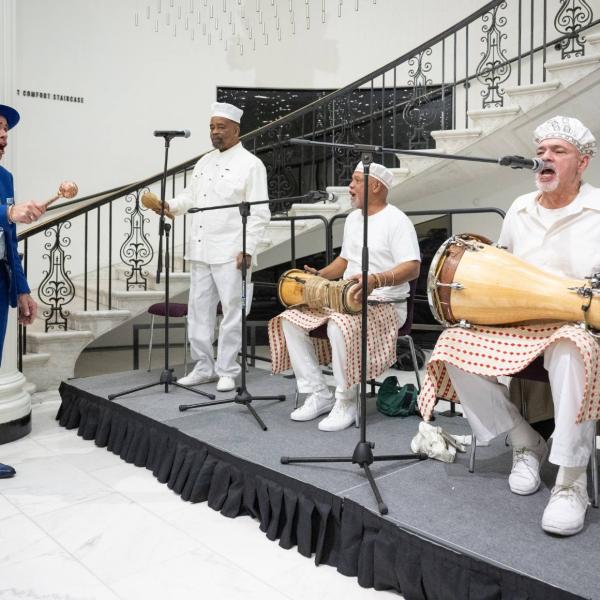 Manny Vega performs with a band of musicians.