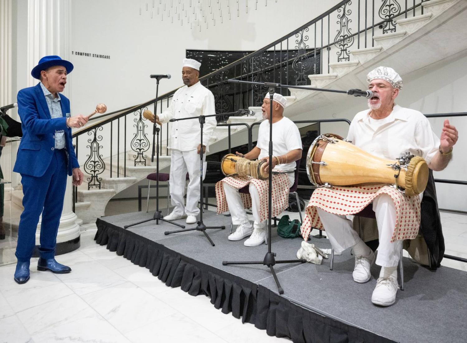 Manny Vega performs with a band of musicians.